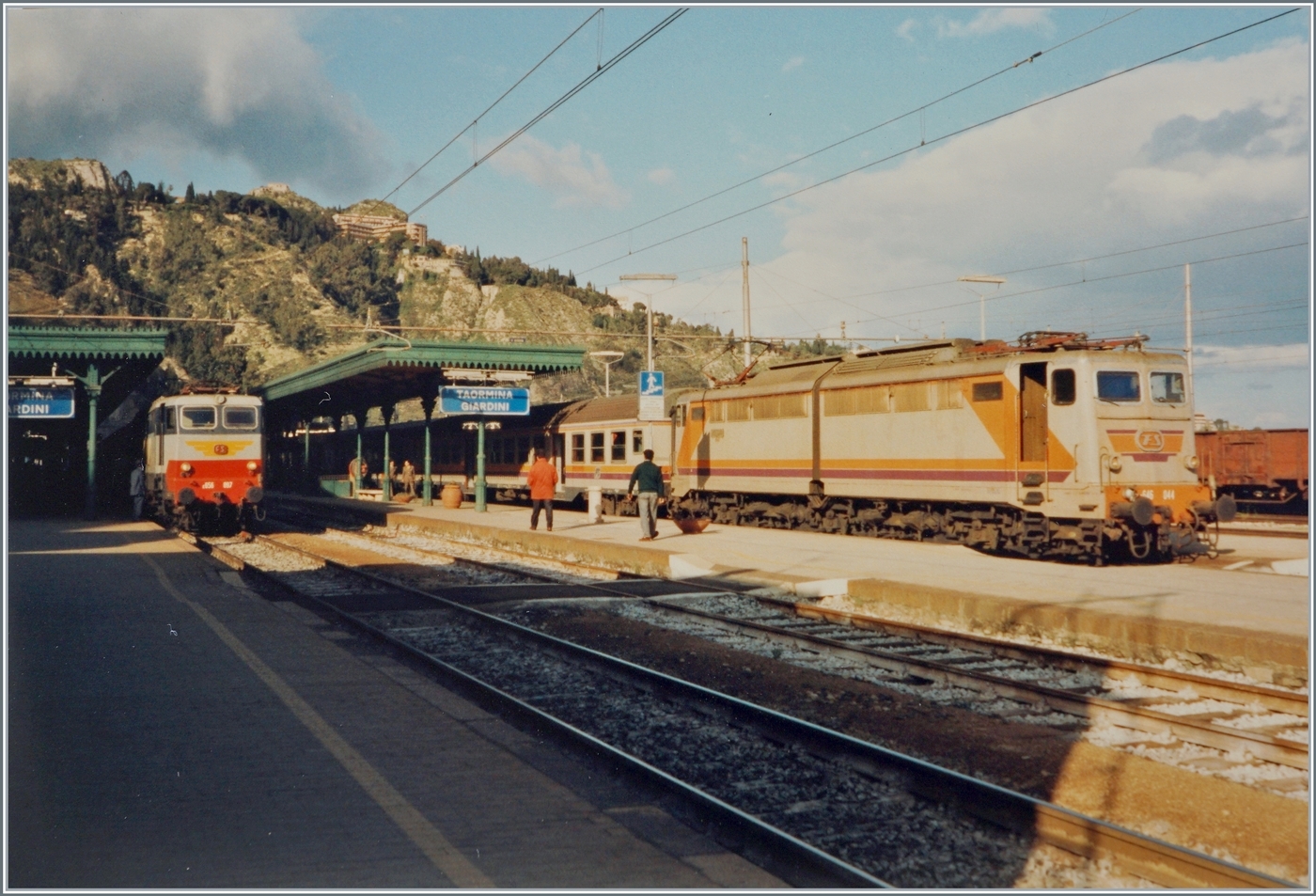 Ein Blick auf den Bahnhof von Taormina-Giardini. Da ich nicht über Aufzeichnungen zu diesem Bild verfüge, interpretiere ich ide Szene folgendermassen: Auf Gleis 3 wartet die FS 646 044 mit ihrem Regionalzug die Überholung des IC aus Roma nach Catania (oder Siracusa) ab. Die FS E 656 097 ist mit ihrem IC  wie zu sehen bereits eingetroffen.

Analogbild vom April 1994