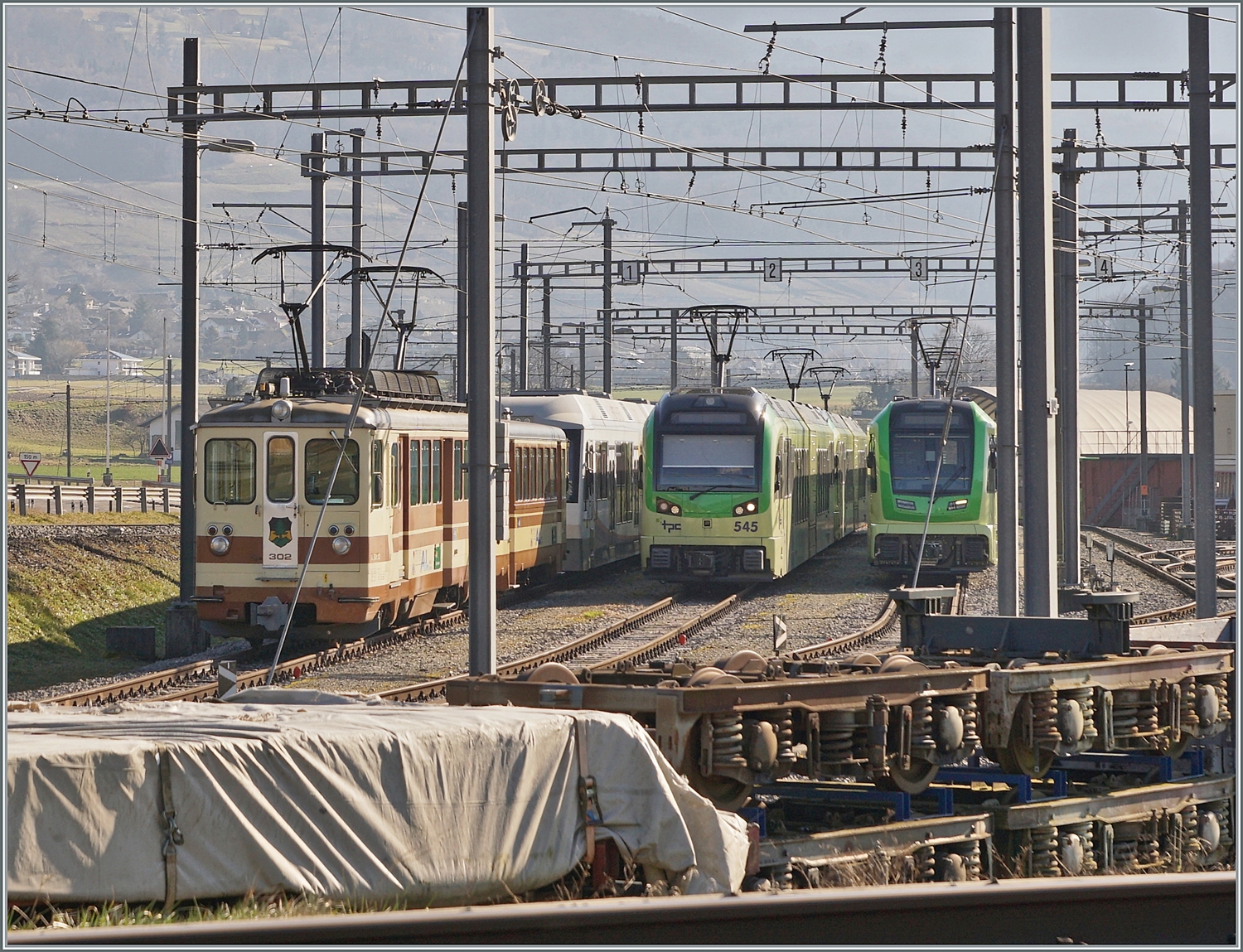 Ein Blick über die SBB Gleise ins TPC Dépôt En Châlet bei Aigle trotz ein wenig störenden Fahrleitungselemente: Rechts steht der AL BDeh 4/4 302, auf dem gleichen Gleis die zweie AVA (ex AAR) Abt, daneben der TPC Beh 2/6 545 und abschliessend ein neuer ABe 4/8. 

4. Feb. 2024