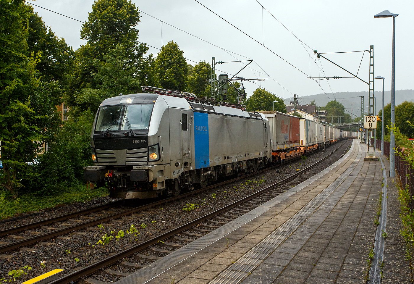 Es begann zu regnen und wir wollten schon den Heimweg antreten, da ging die Schranke am Bü herunter, das kann nur ein Güterzug sein, so ich ging wieder an den Bahnsteig. Die Siemens Vectron MS 6193 185 (91 80 6193 185-6 D-Rpool) der Railpool GmbH (München) fährt am 16 Juli 2025 mit einem KLV-Zug durch den Bahnhof Kirchen/Sieg in Richtung Köln. Nochmals einen lieben Gruß an den freundlichen Lokführer zurück.

Die Multisystemlokomotive Siemens Vectron MS wurde 2024 von SIEMENS Mobilitiy in München-Allach unter der Fabriknummer 23485 gebaut. Sie wurde in der Variante MS A54 ausgeführt und hat so die Zulassungen und Länderpakete für Deutschland, Österreich, Belgien, die Niederlande, Tschechien, die Slowakei, Ungarn, Rumänien und Polen. Für Serbien (SRB), Bulgarien (BG) und Kroatien (HR) sind auch Zulassungen vorgesehen, aber ist z.Z. noch durchgestrichen.

So besitzt die Variante MS A54 folgende Zugsicherungssysteme: ETCS BaseLine 3, sowie für Deutschland (PZB90 / LZB80 (CIR-ELKE I)), für Österreich (ETCS Level 1 mit Euroloop, ETCS Level 2, PZB90 / LZB80), für Belgien (ETCS L1, ETCS L2, TBL1+), für die Niederlande (ETCS Level 1, ETCS Level 2, ATB-EGvV), für Tschechien und die Slowakei (LS (Mirel)), für Ungarn (ETCS Level 1, EVM (Mirel)), für Polen (SHP) und für Rumänien, Serbien, Bulgarien und Kroatien (PZB90).