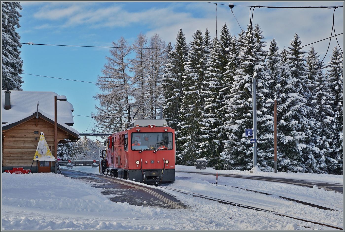 Es hat geschneit und da muss wie üblich die HGem 2/2 2501 mit dem CEV MVR X464 zur Schneeräumung auf den Les Pléiades ausrücken. Das Bild zeigt die HGem 2/2 2501 mit dem X464 nach getaner Arbeit beim Verlassen der Gipfelstation Les Pléiades in Richtung Blonay.

29. Januar 2026