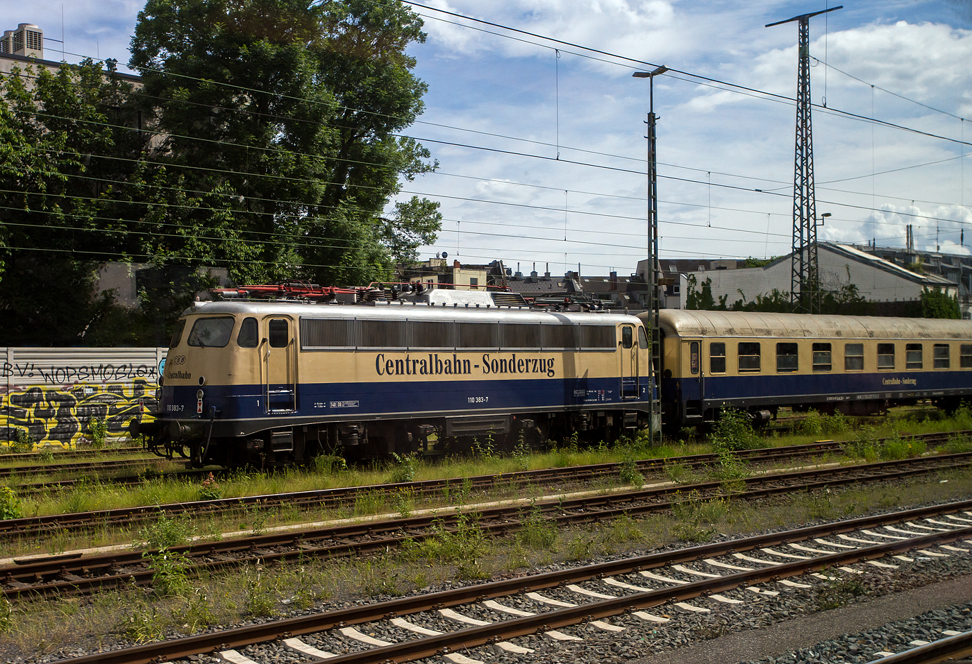 Es sind noch Bügelfalten E 10 im Einsatz. Am16 Mai 2024 konnte ich auch einem Zug heraus in Köln-West die CBB 110 383-7 alias/eigentlich 115 383-2 (91 80 6115 383-2 D-CBB) der Centralbahn GmbH (Mönchengladbach) sehen und ablichten. Die Lok war hier Schlussläufer von einem sehr langen Sonder- oder Partyzug mit 12 Wagen der CBB, als Zuglok war vorne die 111 074-1 „Hilde“ (91 80 6111 074-1 D-DB) der DB Gebrauchtzug.

Die Bügelfalte (E 10) wurde 1965 von der Krauss-Maffei AG in München-Allach unter der Fabriknummer 19158 gebaut, die Elektrik ist von den SSW - Siemens-Schuckert-Werke in Berlin. Sie wurde als E 10 383 an die Deutsche Bundesbahn geliefert. Mit der Einführung des EDV-Nummernsystems wurde sie zum 01.01.1968 zur DB 110 383-7, zum 01.07.2005 ging sie an die DB AutoZug GmbH und wurde so nun zur DB 115 459-0 als solche kam sie 2015 zur DB Fernverkehr AG und wurde zum 16.07.2015 dort ausgemustert. 

Die Lok wurde am 6.September 2016 durch die Centralbahn GmbH erworben und nach Mönchengladbach überführt. Seit Mitte Oktober 2016 ist die in kobaltblau-beiger Farbgebung neu lackierte Lok wieder betriebsfähig.

Warum Baureihe 115 und nicht 110:
Seit 2005 wurden über dreißig 110 und 113 von DB Regio an die damalige DB AutoZug (heute verschmolzen auf die Muttergesellschaft DB Fernverkehr) abgegeben. Um diese Maschinen buchhalterisch besser trennen zu können, erhielten die betroffenen 110 (die technisch E10/110er blieben) seit 2006 nach und nach die neue Baureihenbezeichnung 115 und wurden nach Berlin-Rummelsburg umstationiert, so dass erstmals Maschinen dieser Bauart in Ostdeutschland beheimatet waren.

Das Einsatzfeld der Lokomotiven waren Autozüge, außerdem verrichten sie diverse Übergabedienste und waren teilweise vor Fernzügen, wie zum Beispiel auf der Linie Berlin–Warschau im Einsatz. Im Februar 2020 wurden die 115 198 und 115 261 als letzte Lokomotiven dieser Baureihe abgestellt, sie waren zuletzt als Heizlokomotiven in Berlin-Rummelsburg eingesetzt