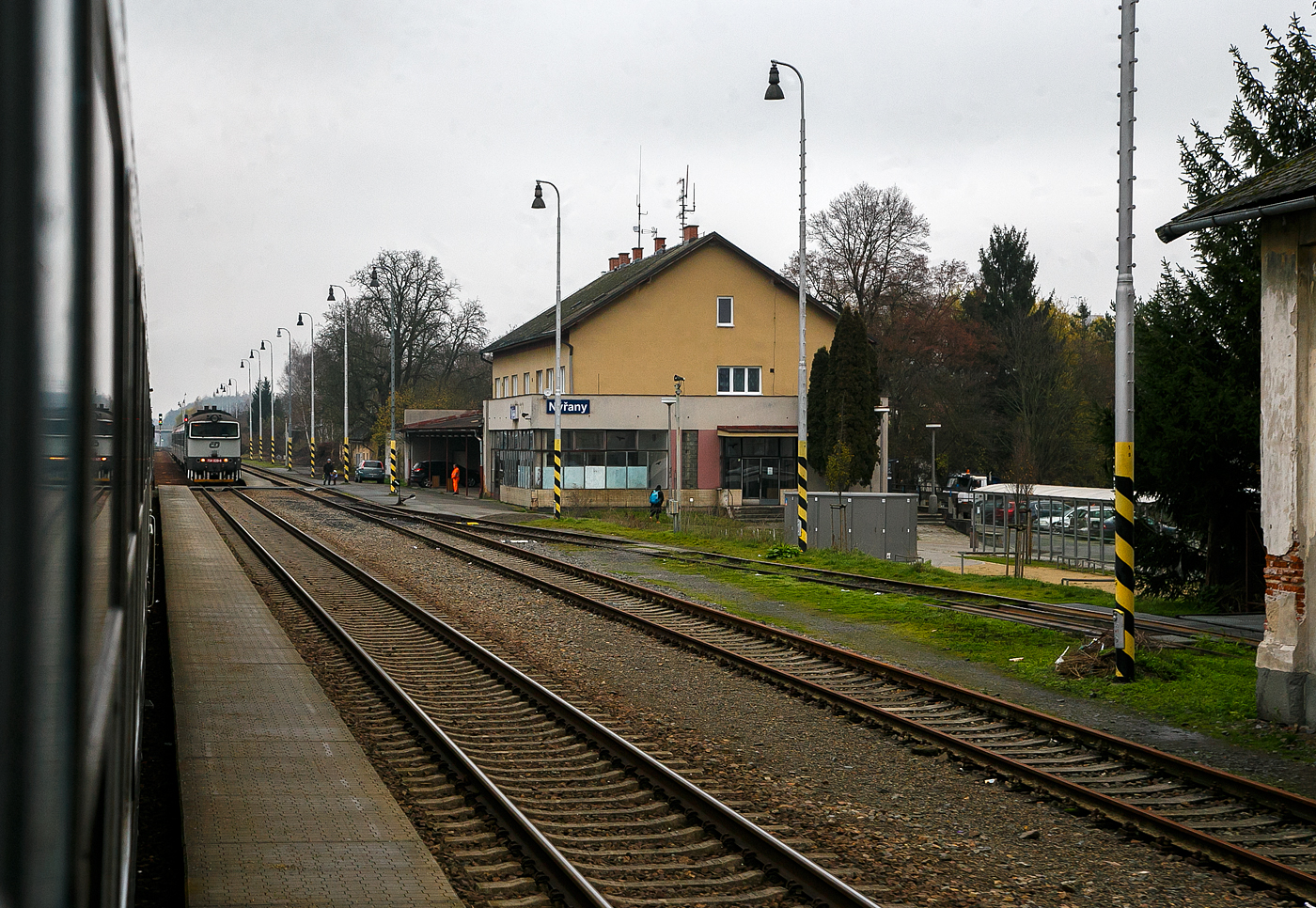 Geführt von der alexa 223 065 (92 80 1223 065-4 D-DLB) fährt unser alex RE 25 / als EX 357 bzw. EC (München – Landshut – Regenburg – Schwandorf – Furth i.W. – Plzeň – Praha), am 22.11.2022 durch den tschechischen Bahnhof Nýřany (Nürschan) auf der „Böhmische Westbahn“ Bahnstrecke Plzeň–Furth im Wald (SŽDC 180).  Ab Furth im Wald wird der Zug als EX 357 (Západní expres / West Express) geführt.

Im Bahnhof steht die „Taucherbrille“ ČD 754 039-6 mit einem Regionalzug.

Die Bahnstrecke Plzeň–Furth im Wald ist eine Eisenbahnverbindung in Tschechien und Deutschland, die ursprünglich von der k.k. priv. Böhmischen Westbahn (BWB) erbaut und betrieben wurde. Sie verläuft von Plzeň (Pilsen) über Nýřany (Nürschan), Staňkov (Stankau) und Domažlice (Taus) nach Furth im Wald, wo sie in die Bahnstrecke Schwandorf–Furth im Wald einmündet.
