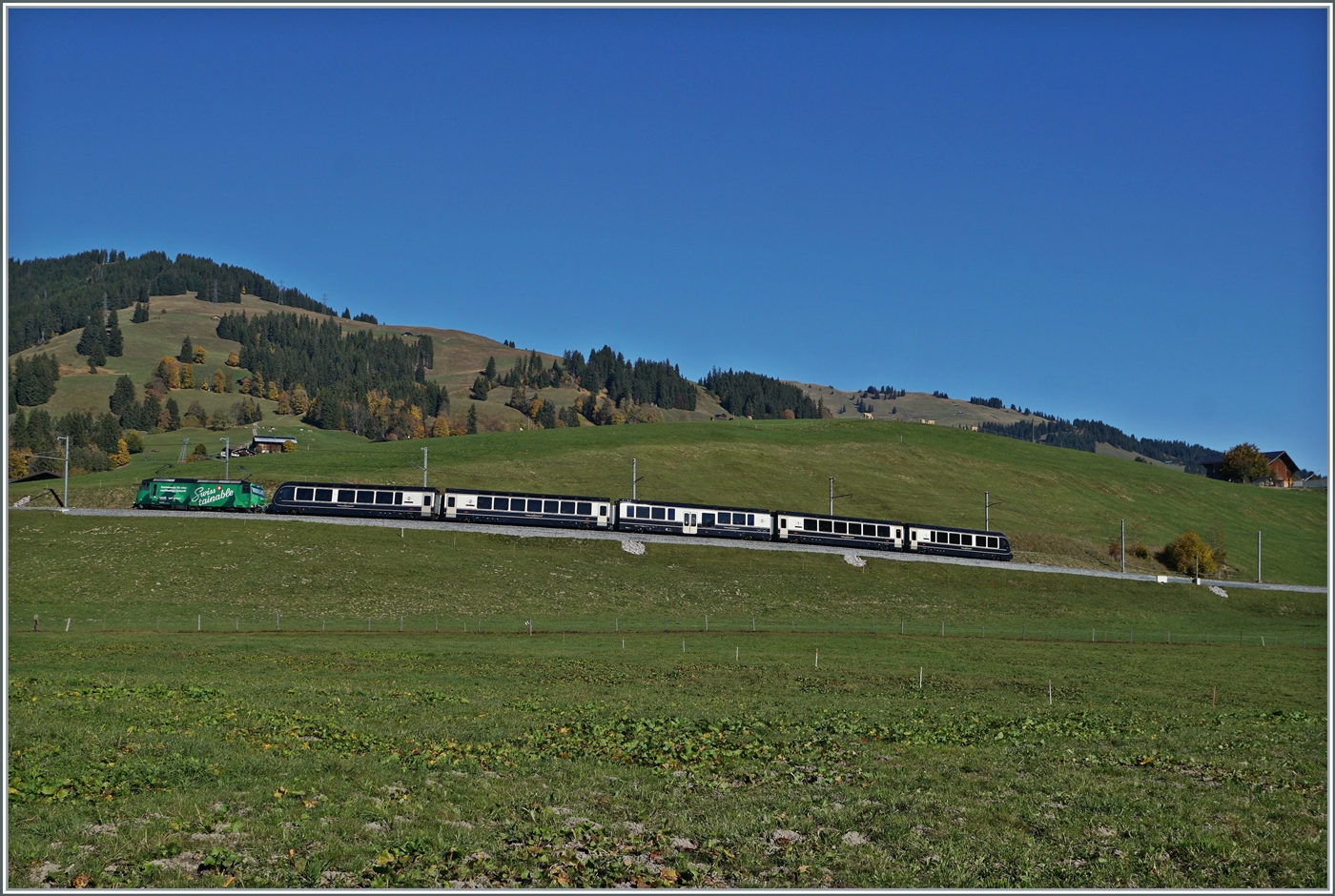 In weiten Kurven gewinnt das Trasse der MOB zwischen Gstaad und Schönried die nötige Höhe. Im Bild der GoldenPass Express (GPX) PE 4068 von Montreux nach Interlaken Ost mit der Ge 4/4 8004  Swisstainable  an der Spitze, die in Zweisimmen durch eine BLS Re 465 abgelöst werden wird.
Das Besondere an diesem Bild: Im Gegensatz zum vorhergehende zeigt dieses Bild nicht die schattige Front der Ge 4/4 8004, sondern die Sonnenbeschiene Rückfront der Lok.

13. Okt. 2025