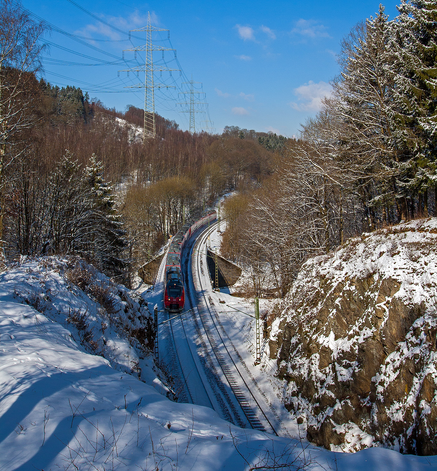 Mitte März 2013 lag sogar an der Sieg noch Schnee...
Zwei gekuppelte Bombardier Talent 2 (fünf- und vierteilig / BR 442/443) fahren am 13 März 2013 als RE 9 - Rhein Sieg Express (RSX) Aachen - Köln – Siegen und überquerem hier bei Scheuerfeld/Sieg kurz vor dem 32 m langen Mühlburg-Tunnel die Sieg. Da hier die Sieg eine Schleife macht, so geht es gleich hinter dem Tunnel wieder die Sieg. Nächster Halt ist dann Betzdorf/Sieg.