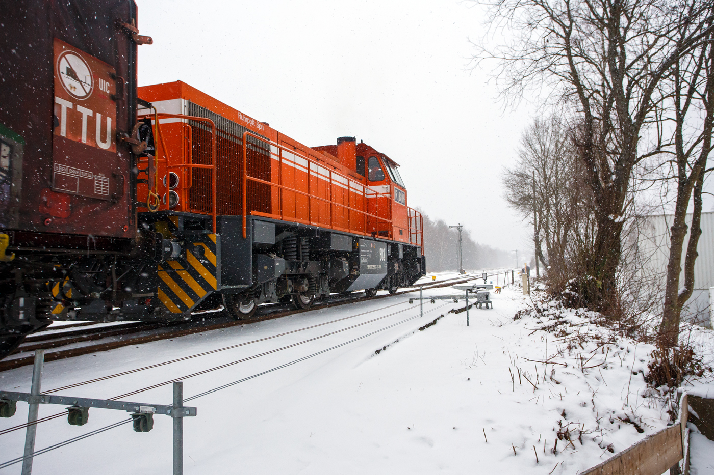 Nun hat es angefangen kräftig zu schneien, die HLB RB 96 „Hellertalbahn“ ist durch und die zurzeit an die KSW (Kreisbahn Siegen-Wittgenstein) vermietete RBH 802 „Ruhrpott Sprinter“ / 275 802-3 (98 80 0275 802-3 D-RBH), eine MaK G 1206 der RBH - RAG Bahn und Hafen GmbH (Gladbeck), kann die Fahrt mit einem Übergabegüterzug beginnen. Der Zug geht via Betzdorf/Sieg und Siegen zum Gbf der DB Cargo in Kreuztal.

Die MaK G 1206 wurde 1997 von der Siemens Schienenfahrzeugtechnik (SFT) in Kiel-Friedrichsort unter der Fabriknummer 1000901 gebaut und an die damalige RAG - Ruhrkohle AG, RAG Bahn- und Hafenbetriebe in Gladbeck als RAG 802 ausgeliefert. Sie war erst die zweite gebaute Lok der erfolgreichen Typs G 1206 aus dem 3. Typenprogramm. Im Jahr 2004 erfolgte die Umfirmierung der RAG in RAG Bahn und Hafen GmbH (RBH) und nach der Übernahme durch die DB Schenker Rail Deutschland AG (heute DB Cargo) erfolgte 2006 die Umfirmierung in RBH Logistics GmbH.