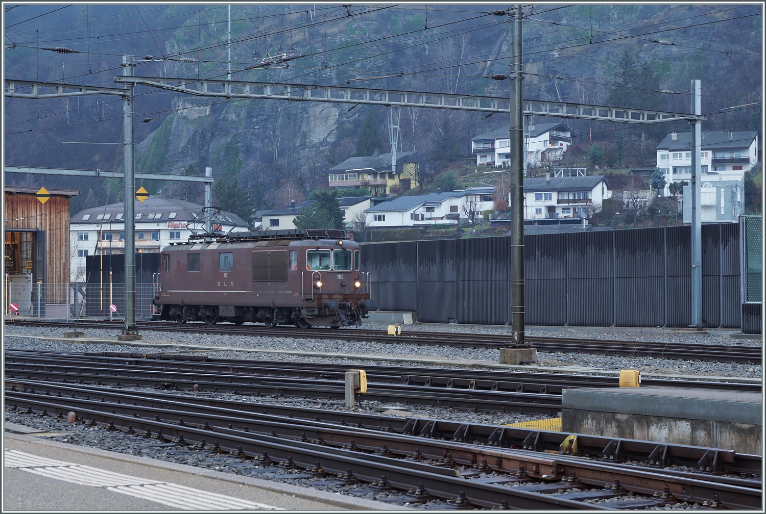 Ob wohl die BLS Re 4/4 (Re 425) noch im Einsatz stehen oder bereits von den Re 465 abgelöst wurden? Dieser Frage wollte ich nach gehen und dazu hatte ich den Plan, nach Kandersteg, Goppenstein und Iselle zu fahren. Da an sämtlichen genannten Orten die Loks im Gegenlicht stehen, war ich nicht auf einen sonnigen Tag erpicht, musste aber infolge schlechter Witterung und einer entsprechenden Gefahrenwarnung Mitte Dezember den Ausflug auf Anfang Januar verschieben. Überraschenderweise und zu meiner Freude, sah ich bereits in Brig eine BLS Re 4/4: Die BLS Re 4/4 182 wartet auf einen nächsten Einsatz.

3. Jan. 2024
