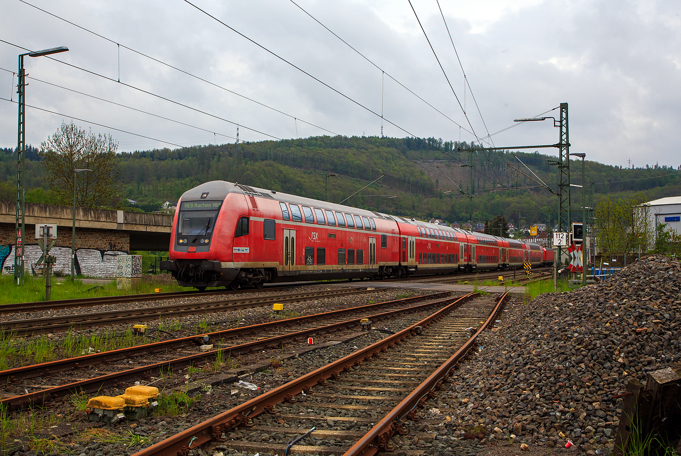Steuerwagen voraus fährt der RE 9 rsx - Rhein-Sieg-Express (Siegen – Köln – Aachen) am 11.05.2023 durch Niederschelden in Richtung Betzdorf (Sieg). 

Der Steuerwagen ist der klimatisierte Doppelstock-Steuerwagen 2. Klasse (DoSto-Steuerwagen) D-DB 50 80 86-75 050-4, der Gattung/Bauart DBpbzfa 763.8, Schublok war die 146 003-9 der DB Regio NRW.

Der Steuerwagen wurde 2000 von der DWA Deutsche Waggonbau AG im Werk Görlitz (ex Waggonbau Görlitz, heute Bombardier) gebaut und in der Gattung/Bauart DBpbzfa 763.6, an die DB Regio NRW für den RE 9 – rsx, geliefert. Die ab 1999 neu beschafften Steuerwagen sind mit einem vergrößerten behindertengerechtem WC ausgestattet, welches die Bauart DBpbzfa 763.6 charakterisiert. Im Oktober 2016 erfolgte im AW Wittenberge der Umbau, wobei der Wagen mit einem zweiten Mehrzweckbereich nachgerüstet und in damit in die Bauart DBpbzfa 763.8 umgezeichnet wurde.

TECHNISCHE DATEN:
Hersteller: DWA Deutsche Waggonbau AG, Werk Görlitz (heute Bombardier)
Umbau bei: AW Wittenberge (2013 bis 2016)
Spurweite: 1.435 mm
Länge über Puffer: 27.270 mm
Wagenkastenlänge: 26.660 mm
Wagenkastenbreite: 2.784 mm
Höhe über Schienenoberkante: 4.631 mm
Drehzapfenabstand: 20.000 mm
Achsstand im Drehgestell: 2.500 mm
Drehgestell Bauart: Görlitz VIII
Leergewicht: 53 t
Höchstgeschwindigkeit: 160 km/h
Heizungsbauart:  Klimaes
Bremsbauart: KE-PR-A-Mg-mZ (D)
Sitzplätze: 85 in der 2. Klasse
Toiletten: 1, behindertengerecht, geschlossenes System
Bemerkungen: 2 Mehrzweckabteile, 1 Dienstraum, eingeschränkt dieselloktauglich
Umgebaut aus: DBpbzfa 763.6