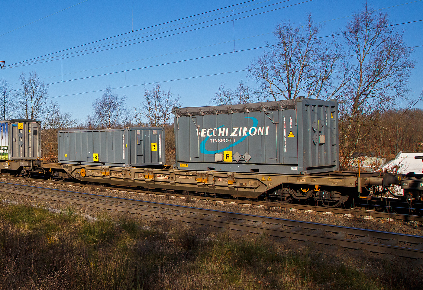Vierachsiger Drehgestell-Taschenwagen für den Transport von Sattelaufliegern und Container, 33 85 4511 034-2 CH-HUPAC, der Gattung Sdgnss, der HUPAC Intermodal SA, im Zugverband am 07.02.2023, bei der Zugdurchfahrt in Rudersdorf (Kr. Siegen), beladen mit zwei Container.

Diese Wagen wurde in den 1990er Jahren von der Waggonfabrik Talbot in Aachen gebaut.
