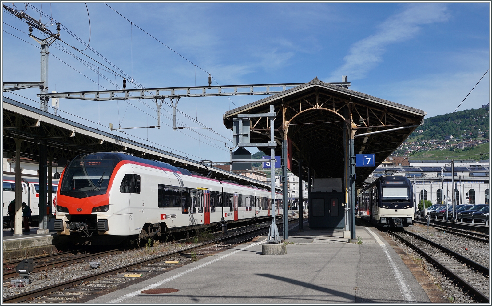 Während auf der  Train des Vignes  Strecke ein SBB RABe 523.5  Mouettes  im Einsatz ist und in Vevey auf Gleis 4 auf die Abfahrt nach Palézieux wartet, steht auf Gleis 7 der CEV MVR ABeh 2/6 7503.

31. Mai 2025