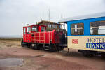 Die DB 399 108-0 (98 80 3399 108-0 D-DB) der Wangerooger Inselbahn am 12 März 2024, mit dem Personenzug und zwei Flachwagen (für Gepäckcontainern) nun ganz leer, Westanleger Wangerooge