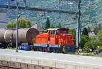 Aus dem Zug heraus, die Em 3/3 163  Rene  (98 85 5837 910-9 CH-LONZA) eine Henschel DHG 500 C der Lonza Group AG (Visp), am 26.05.2023 mit einem Kesselwagenzug im Bahnhof Visp.

Die Henschel  DHG 500 C wurde 1968 von Henschel in Kassel unter Fabriknummer  31239  gebaut und war erst als Mietlok im Einsatz. Im Jahr 1971 verkaufte sie dann Henschel an die Lonza AG in die Schweiz.
2014 wurde die Lok von der LSB Lok Service Balmer AG in Hinwil komplett neu revidiert und remotorisiert.

Die Henschel DHG 500 C ist eine dieselhydraulische Lokomotive, die von den Henschel-Werken gebaut wurde. Sie war vor allem für den Einsatz im schweren Werksdienst vorgesehen. Die Lok gehört zur ab 1962/63 angebotenen sogenannten vierten Generation der Henschel-Loks, der ersten Generation mit Gelenkwellenantrieb. Die Aufbauten wurden dabei ohne große Änderungen von der vorigen Generation übernommen.  Zur besseren Bogenläufigkeit war die mittlere Achse seitenverschiebbar gelagert. 

Von den Henschel DHG 500 C wurde zwischen 1963 und 1976 insgesamt  62 Exemplaren gebaut. Die Loks gingen vornehmlich an Bergbaugesellschaften und Stahlproduzenten sowie Chemieunternehmen. So erwarb die Rheinelbe Bergbau AG in Gelsenkirchen elf Loks und die Hibernia AG, Zechenbahn- und Hafenbetriebe Ruhr-Mitte in Gladbeck neun Loks vom Typ DHG 500 C. Die meisten Lokomotiven wiesen bei Auslieferung den Henschel-Standardanstrich in Blau mit zwei horizontalen Zierstreifen an den Vorbauten auf. Die durch Zusammenschluss entstandene Ruhrkohle AG hatte zeitweise 31 Lokomotiven dieses Typs im Bestand. 

TECHNISCHE DATEN (nach Umbau):
Spurweite:  1.435 mm (Normalspur)
Achsformel: C
Länge über Puffer:  9.900 mm
Höhe:  4.225 mm
Breite: 3.040 mm
Fester Radstand:  3.700 mm
Kleinster bef. Halbmesser:  80 m
Dienstgewicht:  60 t
Höchstgeschwindigkeit: 30 km/h / 60 km/h (Schleppfahrt 70 km/h)
Treibraddurchmesser:  1.000 mm
Motor:  neuer Deutz V6 Motor mit elastischer Vorschaltkupplung. inkl. Partikelfilter (Vollstrombrenner mit aktiver Regeneration), 
der ehemalige Motor war ein Henschel 12V 1416 
Installierte Leistung:  368 kW (500 PS)
Getriebe:  Voith
Leistungsübertragung:  hydraulisch (über Gelenkwellen)
