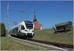 Der TPF RABe 527 198  BCF / FKB  (Kantonalbankwerbezug) erreicht Vaulruz, links im Bild die mittlerweile bekannte Kapelle von Vaulruz, rechts, die hier typischen an den Gleisböschung stehenden